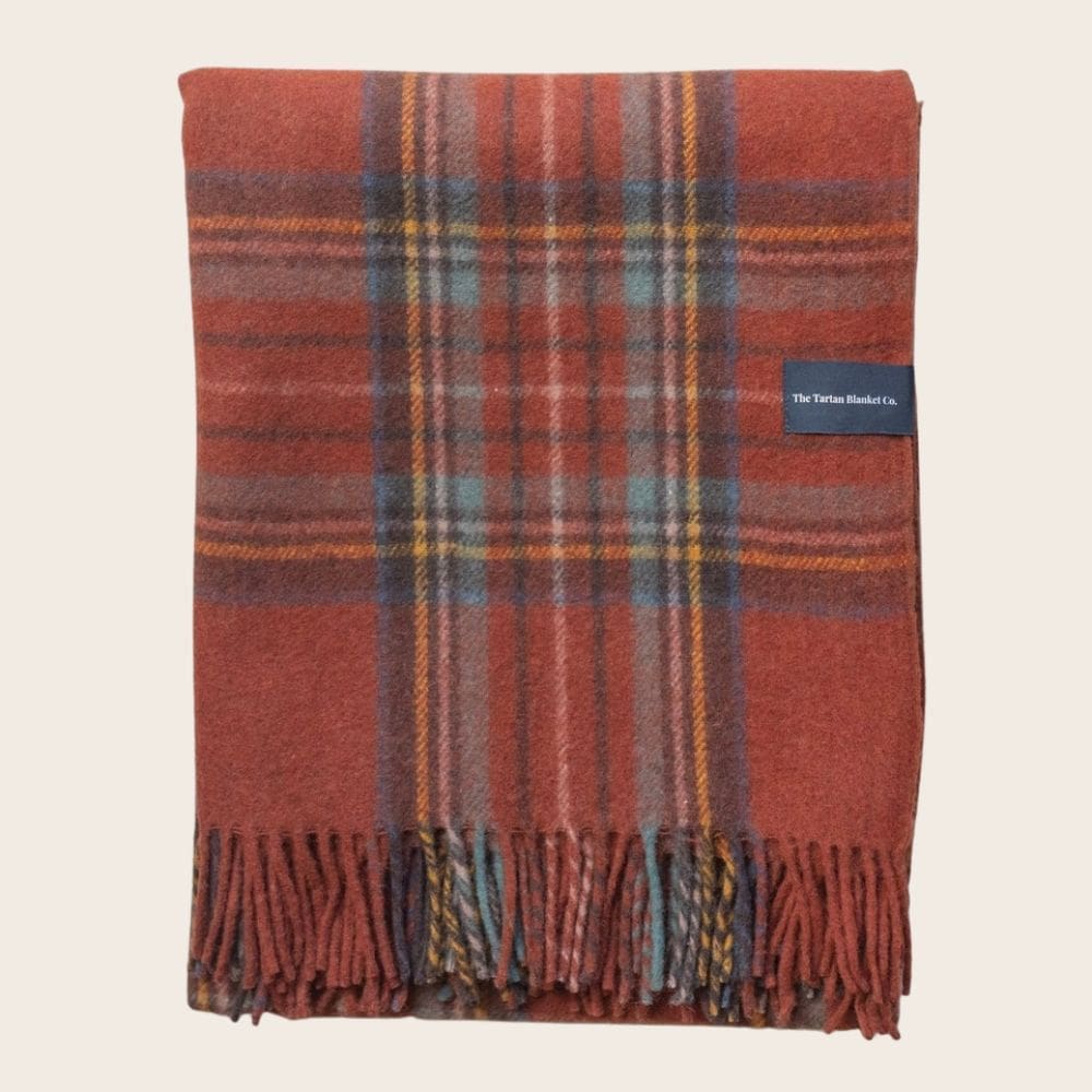 Warm oranje opgevouwen wollen deken in Stewart tartan