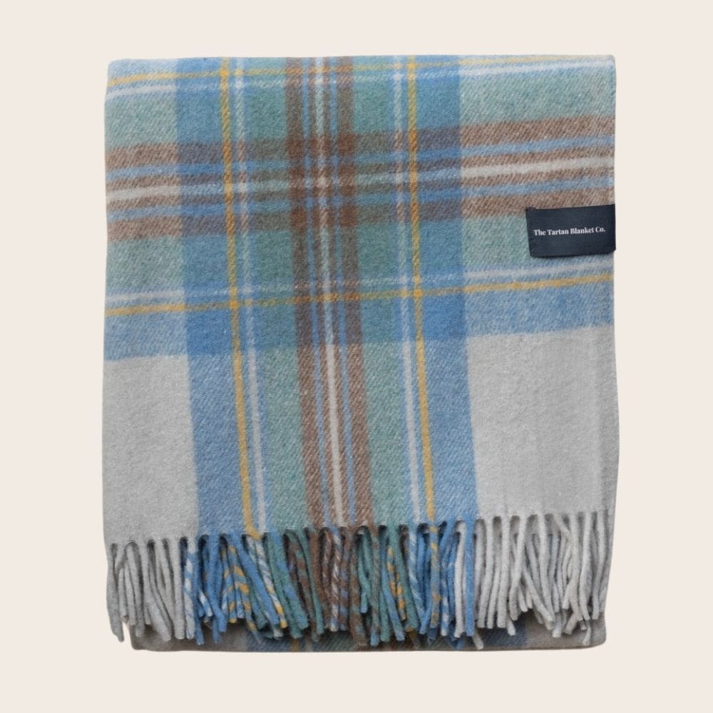 Opgevouwen tartan deken in lichtblauwe Stewart ruit.