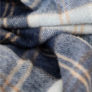 Detail van een wollen tartan omslagdoek in donkerblauw met grijs