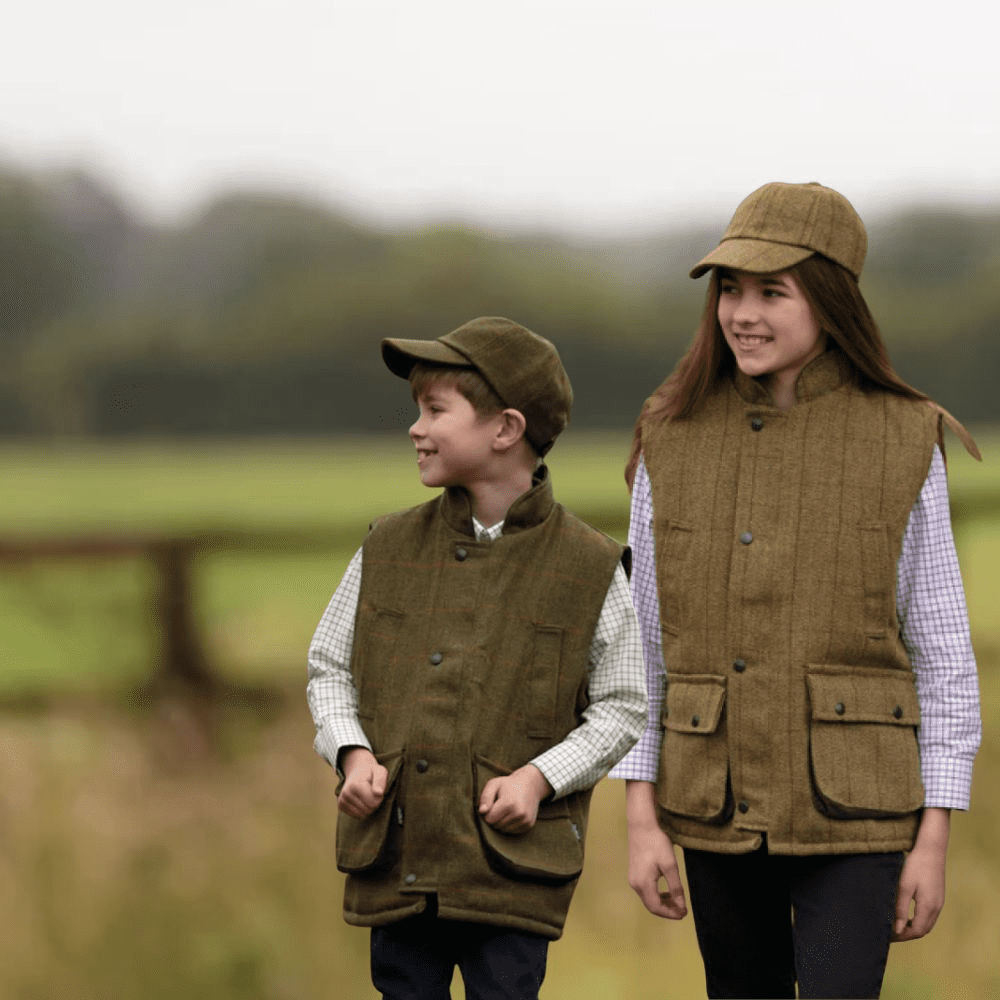 jongen en meisje gekleed in tweed shooting gilet